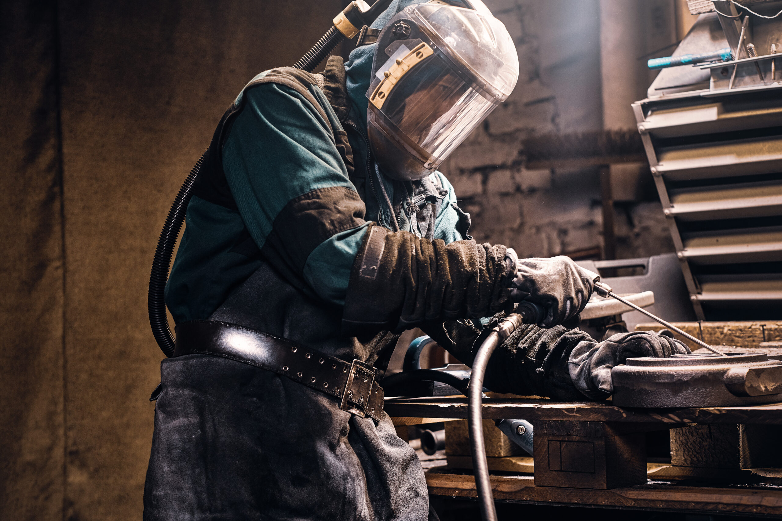 Diligent man is working with metal at workshop